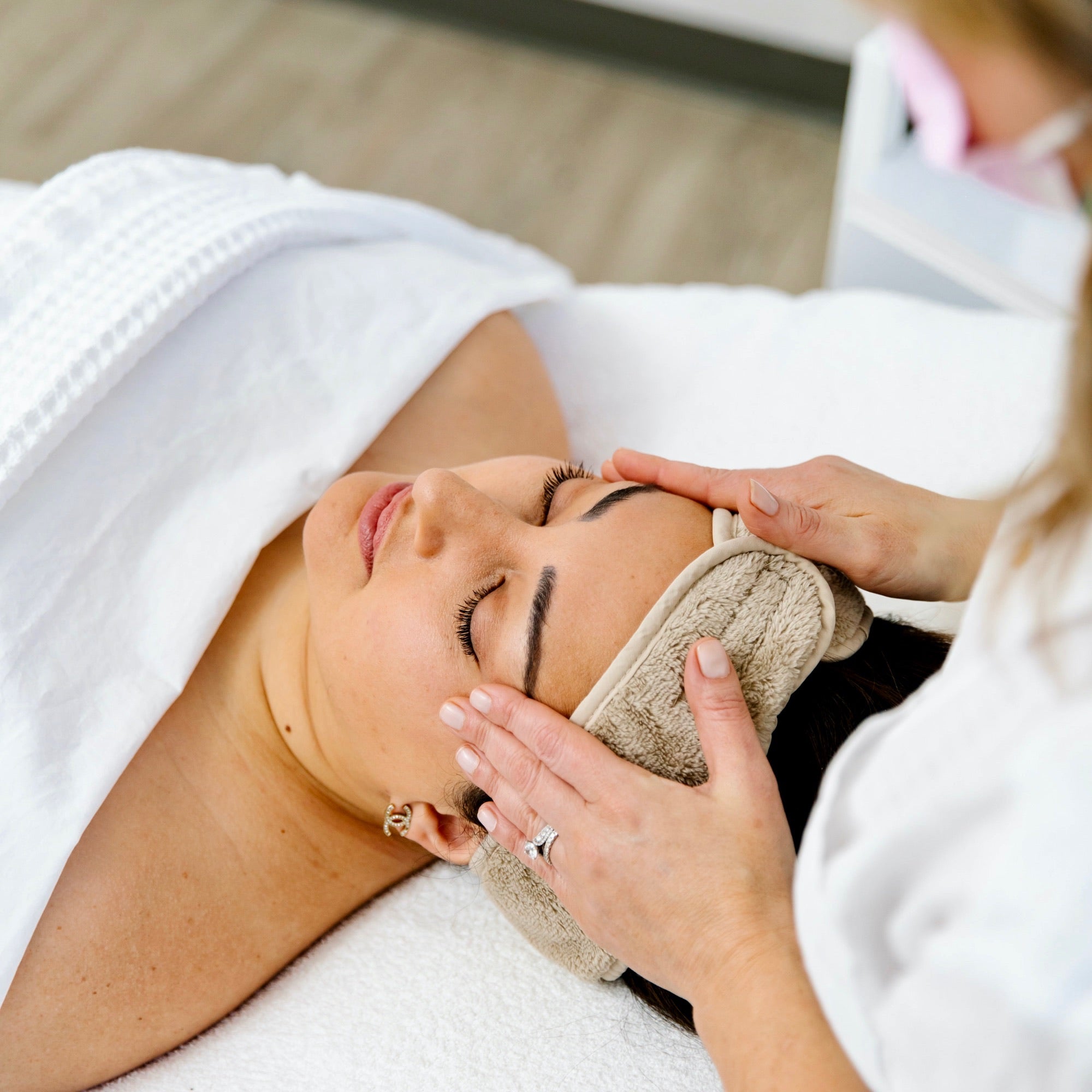 Esthetician looking at client's skin before facial