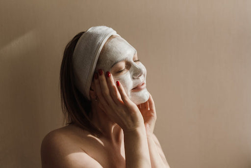 Woman relaxing with a Biologique Recherche facial mask, illustrating the anti-aging benefits and skin rejuvenation process.