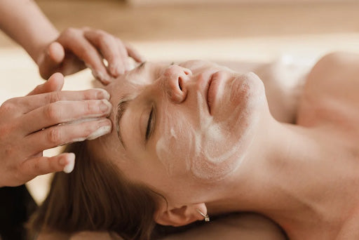 Skincare treatment during a quick facial session, featuring a woman receiving a gentle face massage with cleansing cream, promoting healthy & glowing skin.