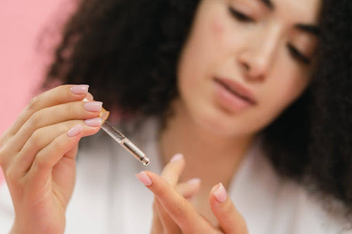 A woman examines a dropper of Biologique Recherche anti-aging serum, focusing on its effects and quality.