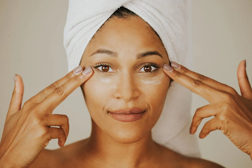 Woman applying eye cream, demonstrating a benefit of Biologique Recherche cremes for youthful skin.