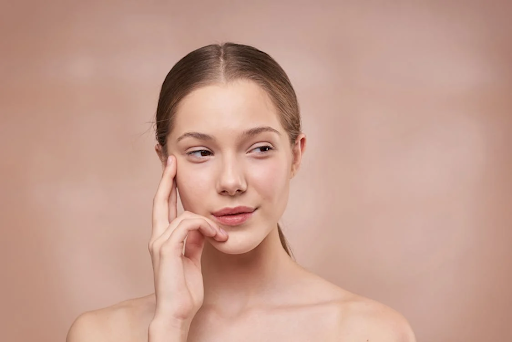 Young woman touching her face, showcasing clear, radiant skin ideal for Lotion P50's skincare benefits.