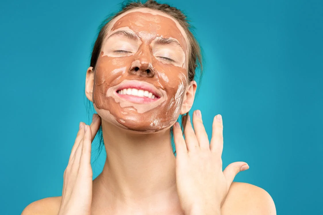Smiling woman enjoying the benefits of a Biologique Recherche mask, showcasing radiant skin after applying a purifying and hydrating skincare treatment.