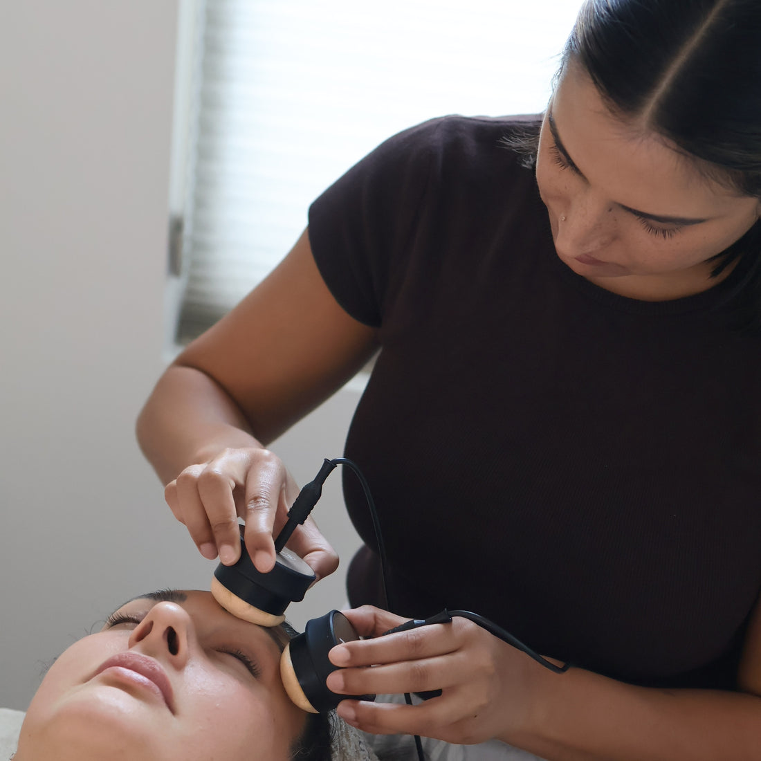 Person receiving a microcurrent facial treatment by Skin & Tonic esthetician.